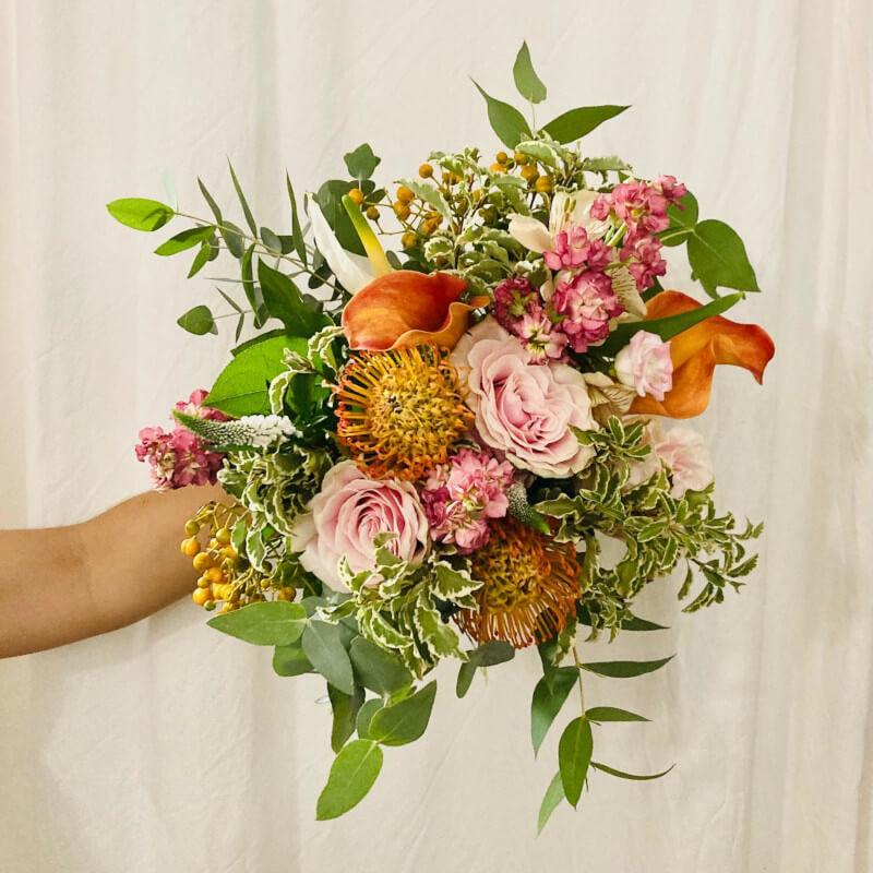 Babette flower bouquet with vibrant orange and pink wildflowers, handcrafted by Adhoc Flores for same-day delivery in Madrid.